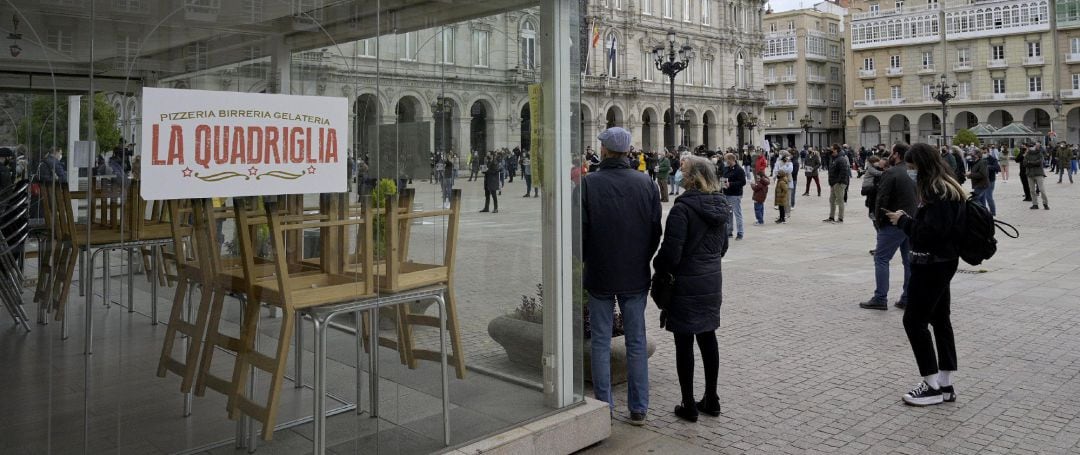 Grupos de personas se concentran en fila de a cuatro en la plaza de María Pita contra las restricciones impuestas al sector hostelero, en A Coruña