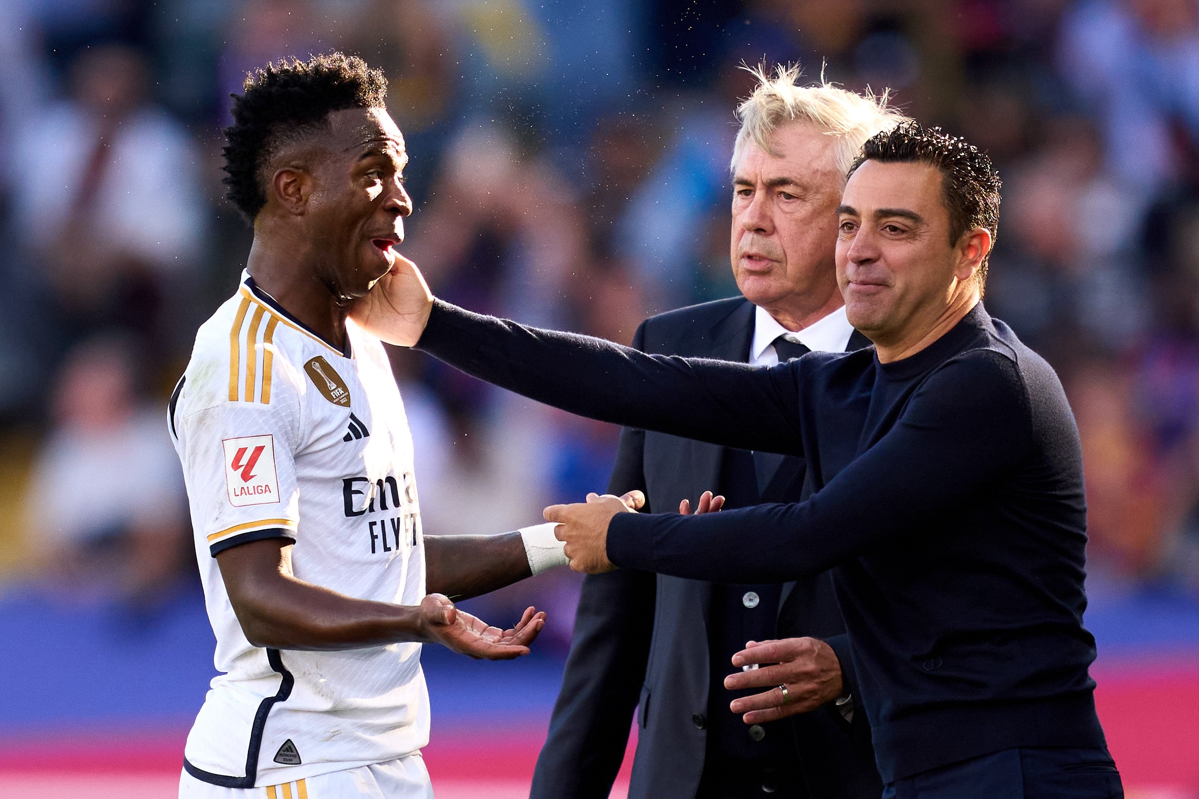 Xavi toca la cara de Vinicius bajo la atenta mirada de Ancelotti