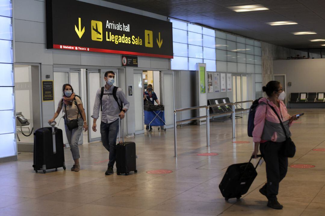 Foto de archivo de personas con mascarilla en un aeropuerto