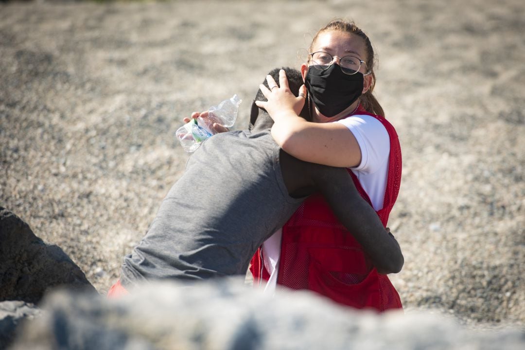 Momento del abrazo entre Luna, voluntaria de Cruz Roja, y Abdou, joven senegalés cuyo hermano estaba siendo reanimado a su lado