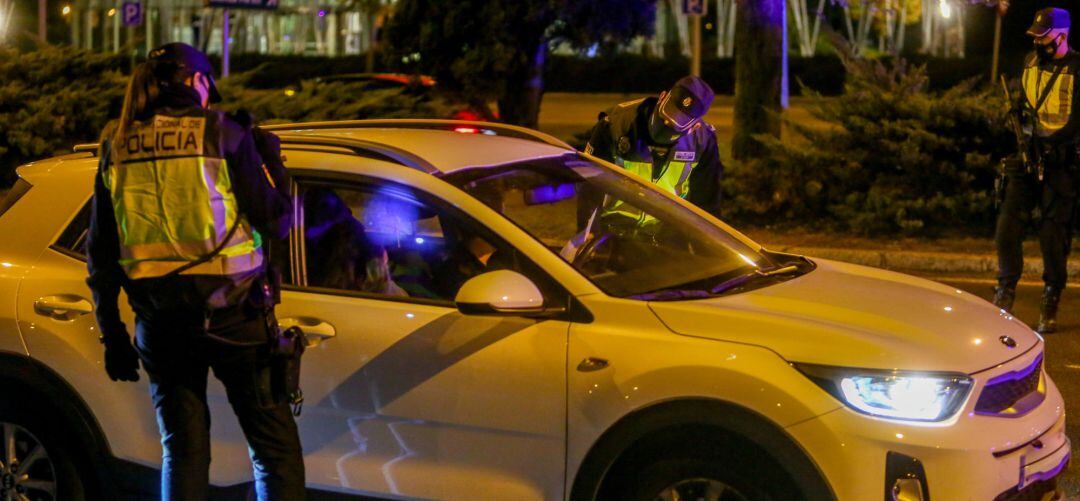 Dos policías nacionales parana un coche durante un dispositivo de seguridad