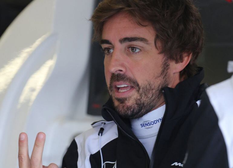 Fernando Alonso habla con sus mecánicos en el box