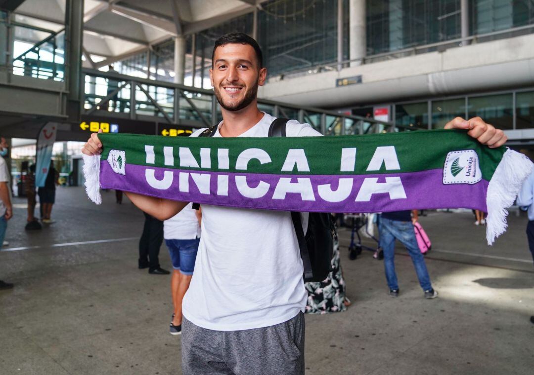 Marco Spissu, posando con una bufanda del Unicaja en su llegada a Málaga.