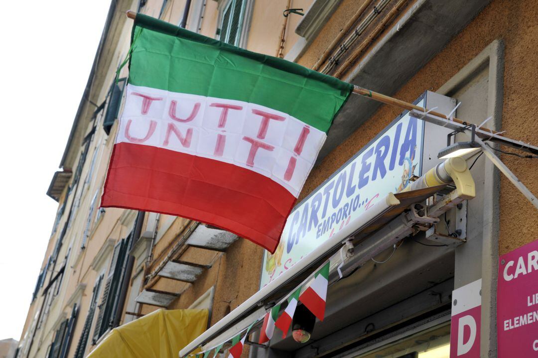 Imagen de una tienda que ha reabierto este miércoles en Livorno y en cuya bandera se puede leer &quot;todos unidos&quot;