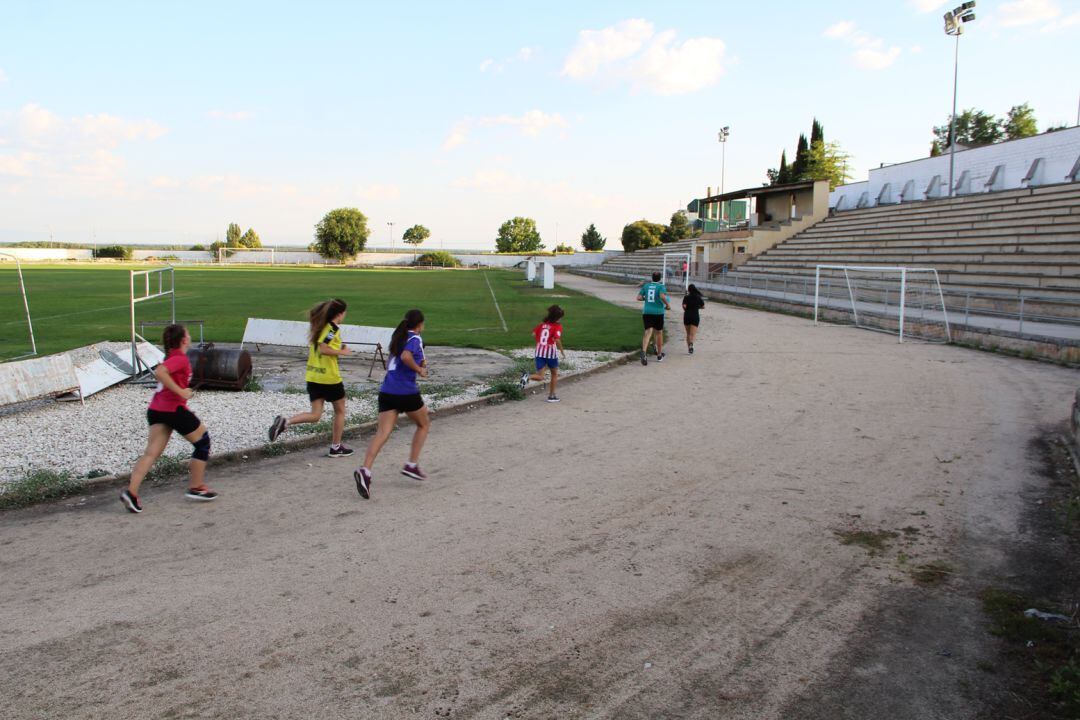 Un grupo de deportistas corre por las pistas de atletismo en el campo de fútbol de Cuéllar