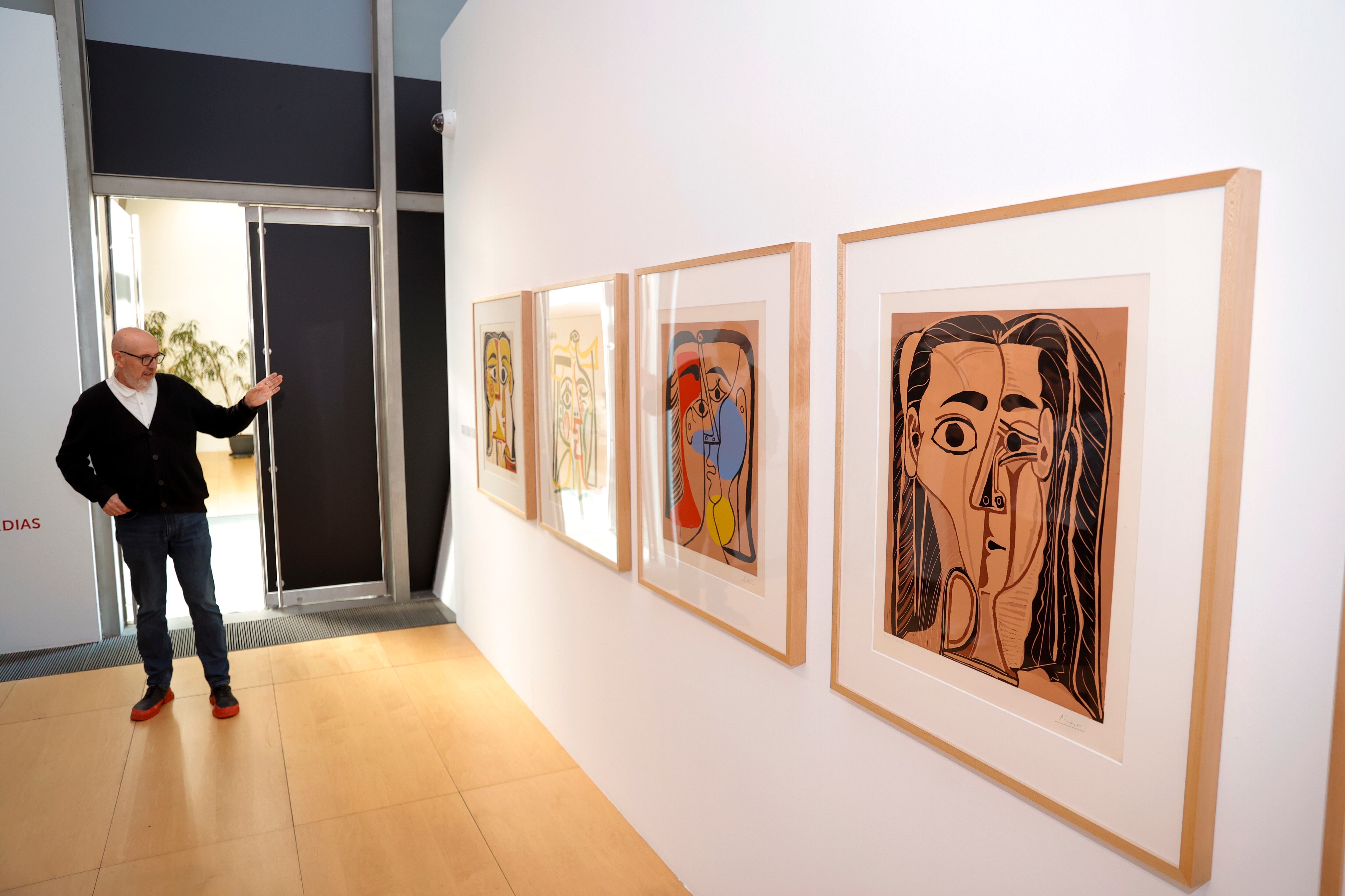 A CORUÑA, 14/10/25.- El comisario de la muestra, 'Compromiso con el arte', junto a obras que forman parte de la misma durante la presentación este martes en A Coruña. L exposición reúne 77 obras de las colecciones de arte de Abanaca y Fundación Bancaja. EFE/Cabalar