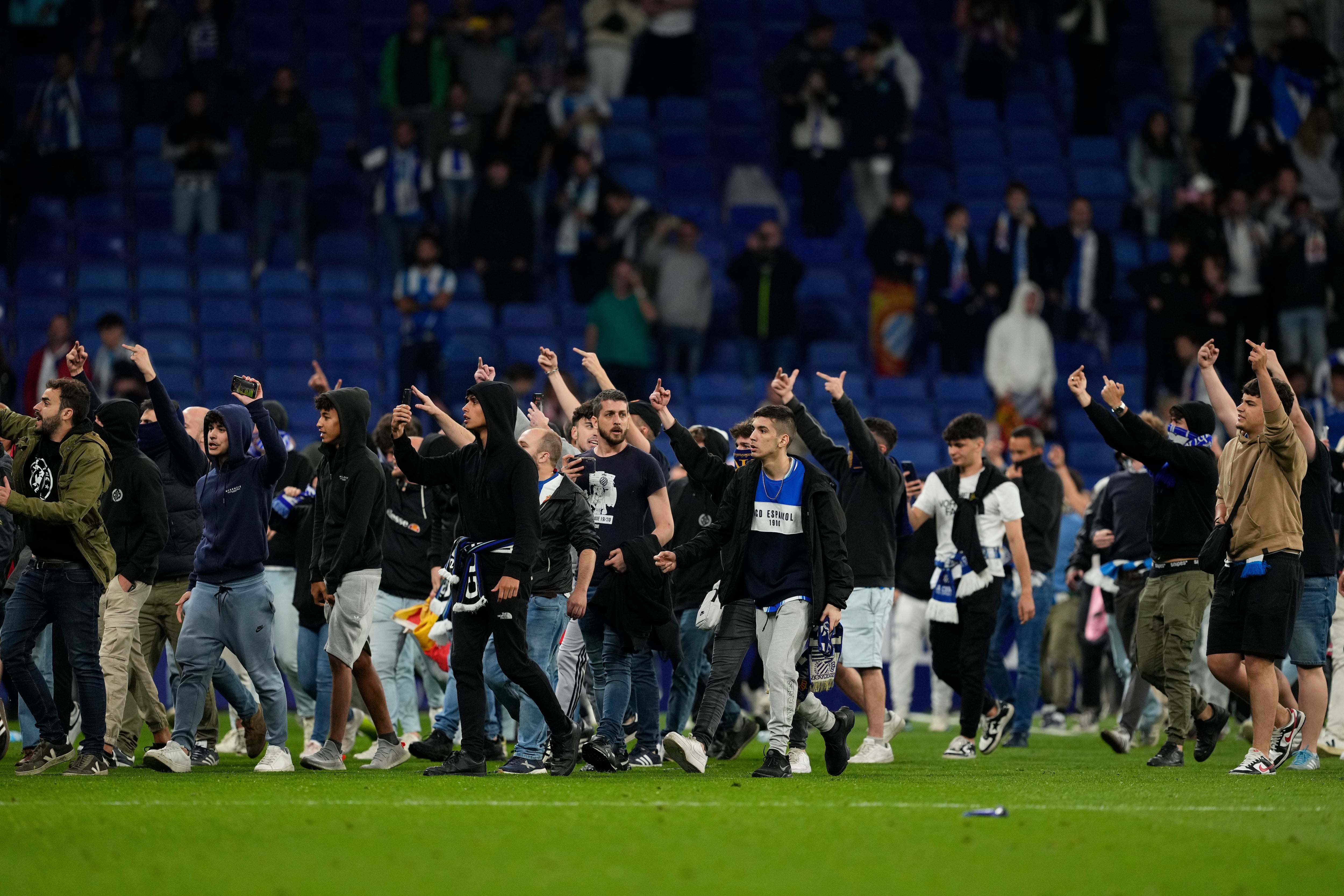 Cientos de aficionados invaden el campo al término del partido que el RCD Espanyol y el FC Barcelona en el RCDE Stadium