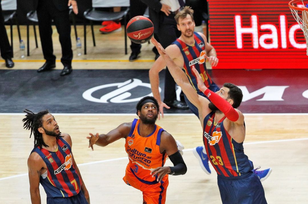 GRAFCVA6375. VALENCIA, El escolta estadounidense de Valencia Basket, Jordan Loyd, observa como trata de taponar su lanzamiento el ala pívot georgiano de Kirolbet Baskonia, Tornike Shengelia, durante la disputa de la segunda semifinal de la fase final de la Liga Endesa en el pabellón de la Fuente de San Luis de Valéncia. EFE. Manuel Bruque