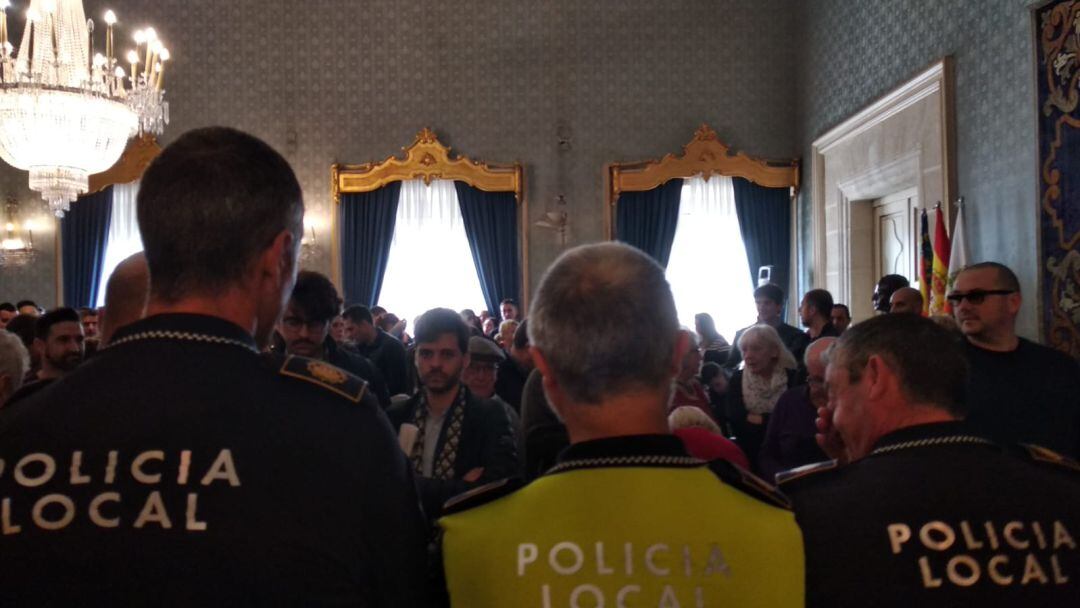 Funcionarios municipales protestan en el pleno detrás de efectivos de la Policía Local