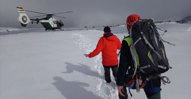 El senderista se dirige hacia un helicóptero de salvamento junto a un guardia civil.