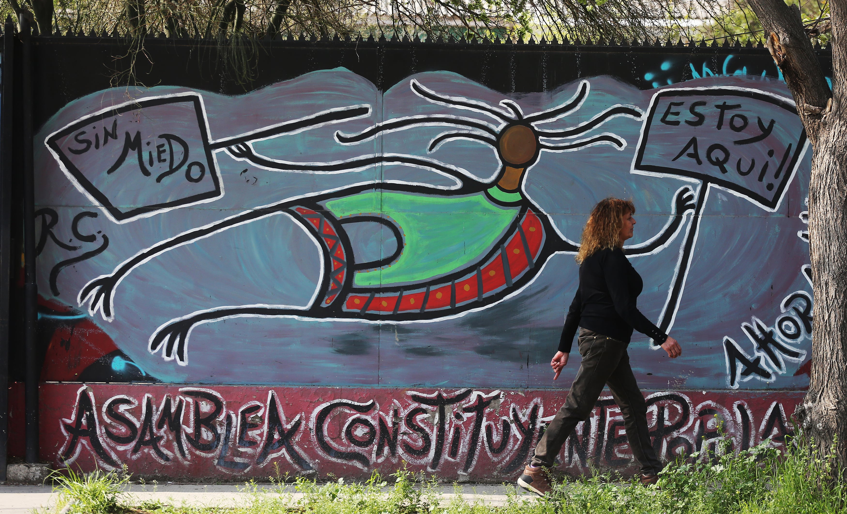 CH0. SANTIAGO (CHILE), 16/09/2022.- Una mujer camina frente a un mural sobre la Asamblea Constituyente, el martes 13 de septiembre de 2022, en Santiago (Chile). Los resultados del plebiscito constitucional del 4 de septiembre dejaron un apabullante triunfo de casi el 62 % de los votos del &quot;Rechazo&quot;, prácticamente sin excepciones: solo ocho en ocho de las 346 comunas del país se aprobó la propuesta de nueva Constitución. Fuera del territorio insular, donde se registraron los mejores resultados para el Apruebo, Pedro Aguirre Cerda es la comuna que obtuvo mayor porcentaje, con el 54,9% de los votos. El rechazo se quedó con el 45,1%. EFE/ Elvis González
