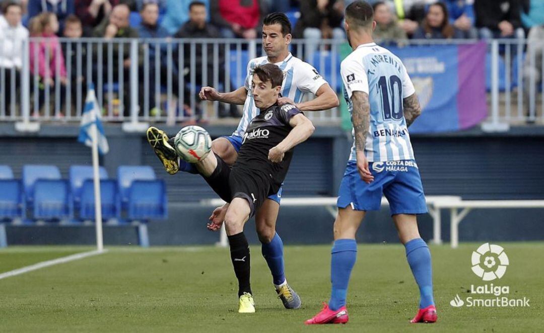 Guillermo pelea un balón ante Luis Hernández y Tete Morente