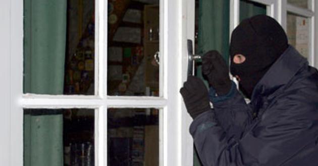 Un ladrón intenta forzar la cerradura de una vivienda