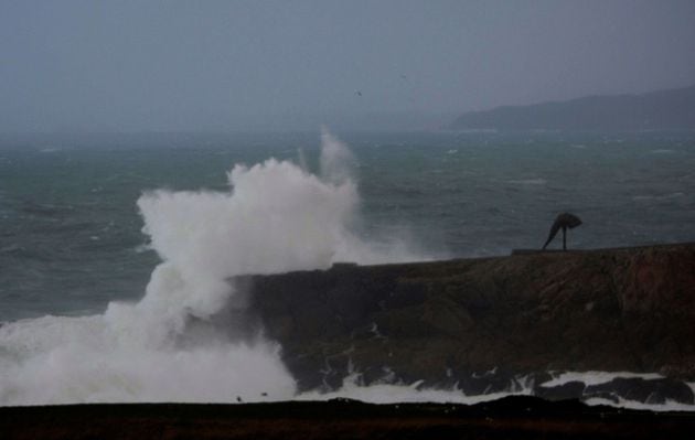 Las olas rompen con fuerza contra las rocas de la costa de la ciudad de A Coruña, este lunes en el que la borrasca Bella seguirá aportando inestabilidad, con todo el litoral gallego en alerta, de nivel rojo en A Coruña.