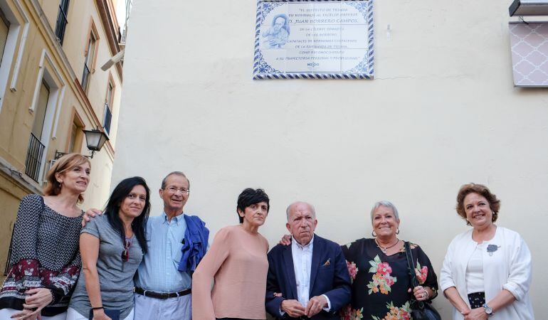 El orfebre y capataz Juan Borrero, bajo el azulejo cerámico con el que se le recuerda en Triana, junto a familiares y, a la derecha, la delegada municipal del Distrito, Carmen Castreño