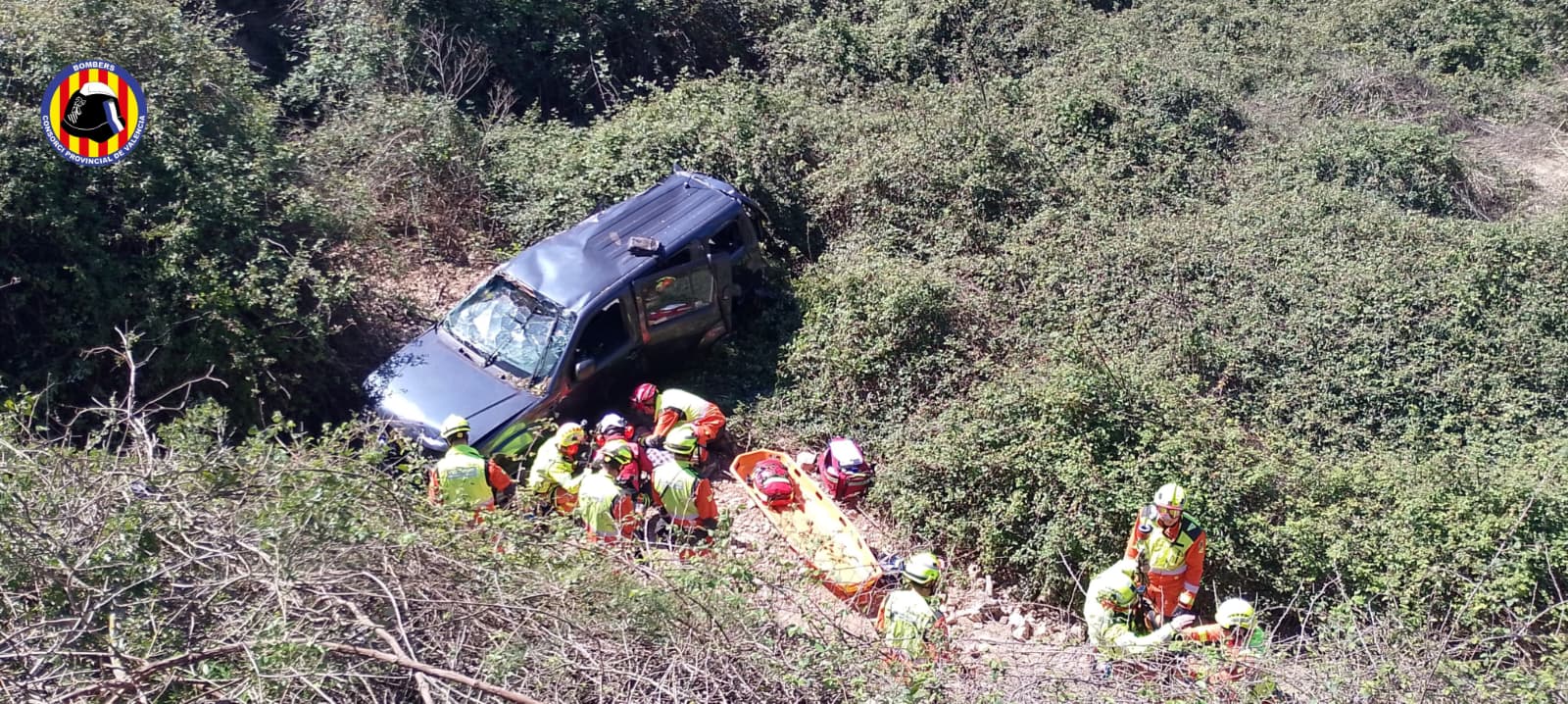 Efectivos del Grupo de Rescate en Altura (GERA) del Consorcio de Bomberos de València proceden a la extracción aérea del conductor mediante el helicóptero V-990, tras estabilizarlo en el fondo del barranco en Aielo de Malferit