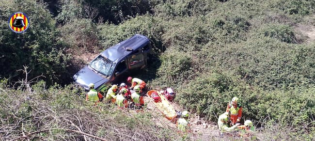 Efectivos del Grupo de Rescate en Altura (GERA) del Consorcio de Bomberos de València proceden a la extracción aérea del conductor mediante el helicóptero V-990, tras estabilizarlo en el fondo del barranco en Aielo de Malferit