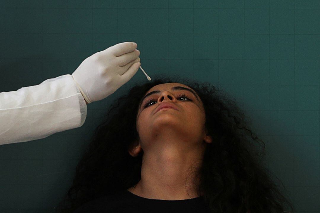 Un sanitario realiza una prueba PCR a una ciudadana.