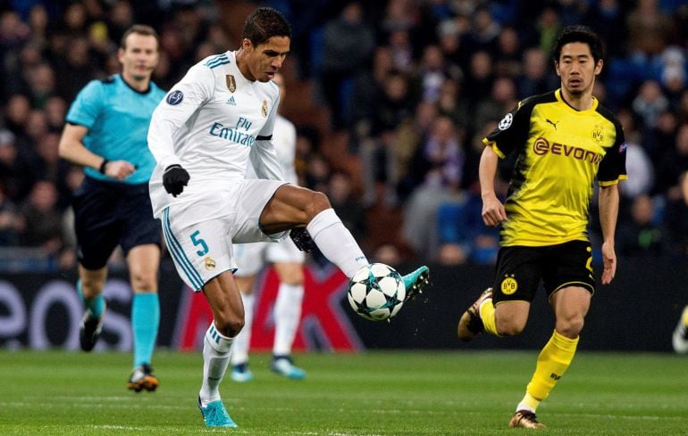 El defensa francés del Real Madrid Raphael Varane (i) pelea un balón con el delantero japonés del Borussia Dortmund, Shinji Kagawa