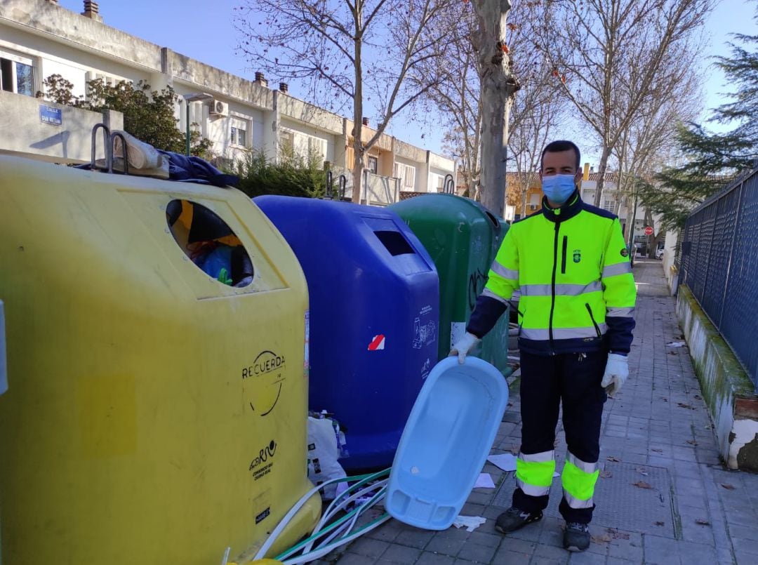 Un trabajador de limpieza recoge residuos depositados fuera de los contenedores en un barrio de la capital