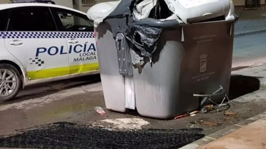 Imagen de archivo de un coche de la Policía Local y un contenedor quemado / POLICÍA LOCAL DE MÁLAGA