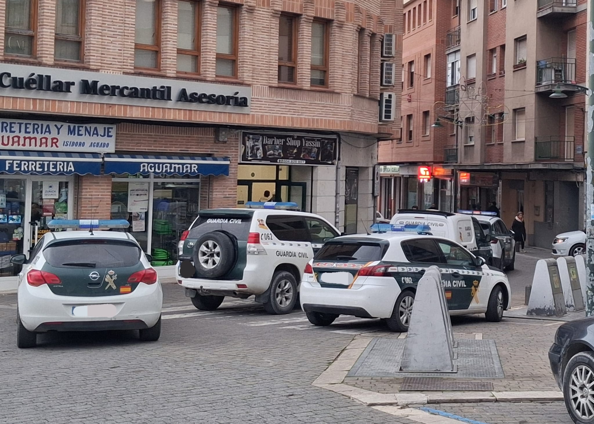 Vehículos de la Guardia Civil cierran el paso en la calle Huertas de Cuéllar mientras inspeccionan varios locales