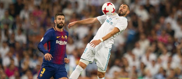 Piqué y Benzema en un Clásico entre el Real Madrid y el Barcelona.