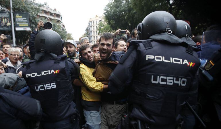 Agentes antidisturbios de la Policía Nacional forman un cordón de seguridad frente al colegio Ramón Llull de Barcelona.