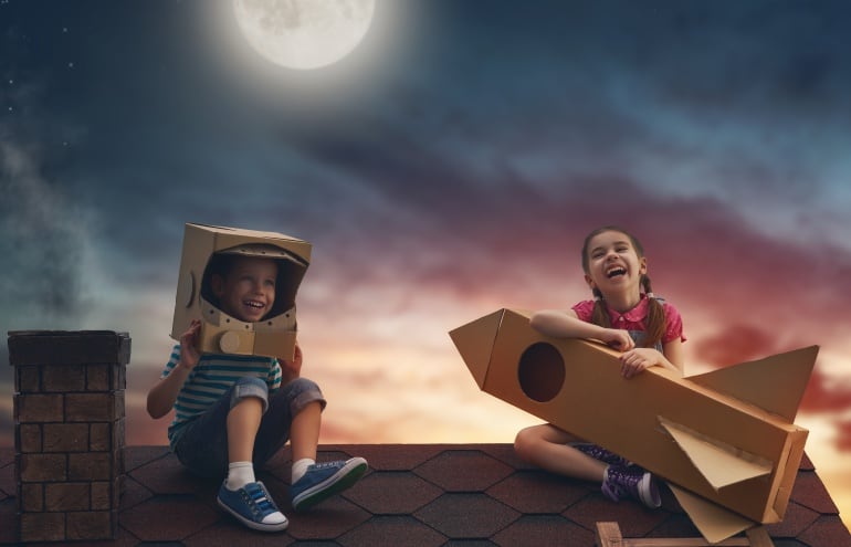 Imagen de dos niños en un tejado jugando a ser astronautas.