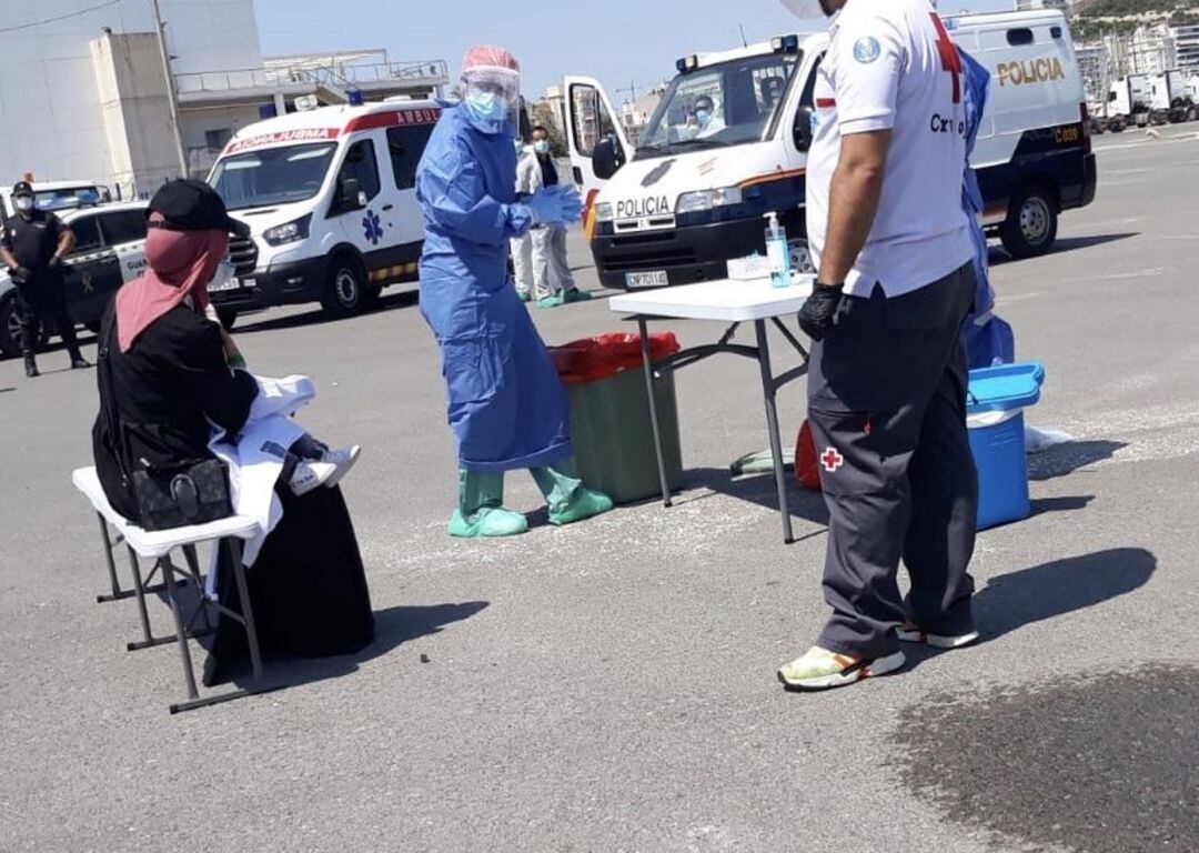 Voluntarios de Cruz Roja prestan asistencia a una de las mujeres inmigrantes que llegó en patera a la costa de Alicante