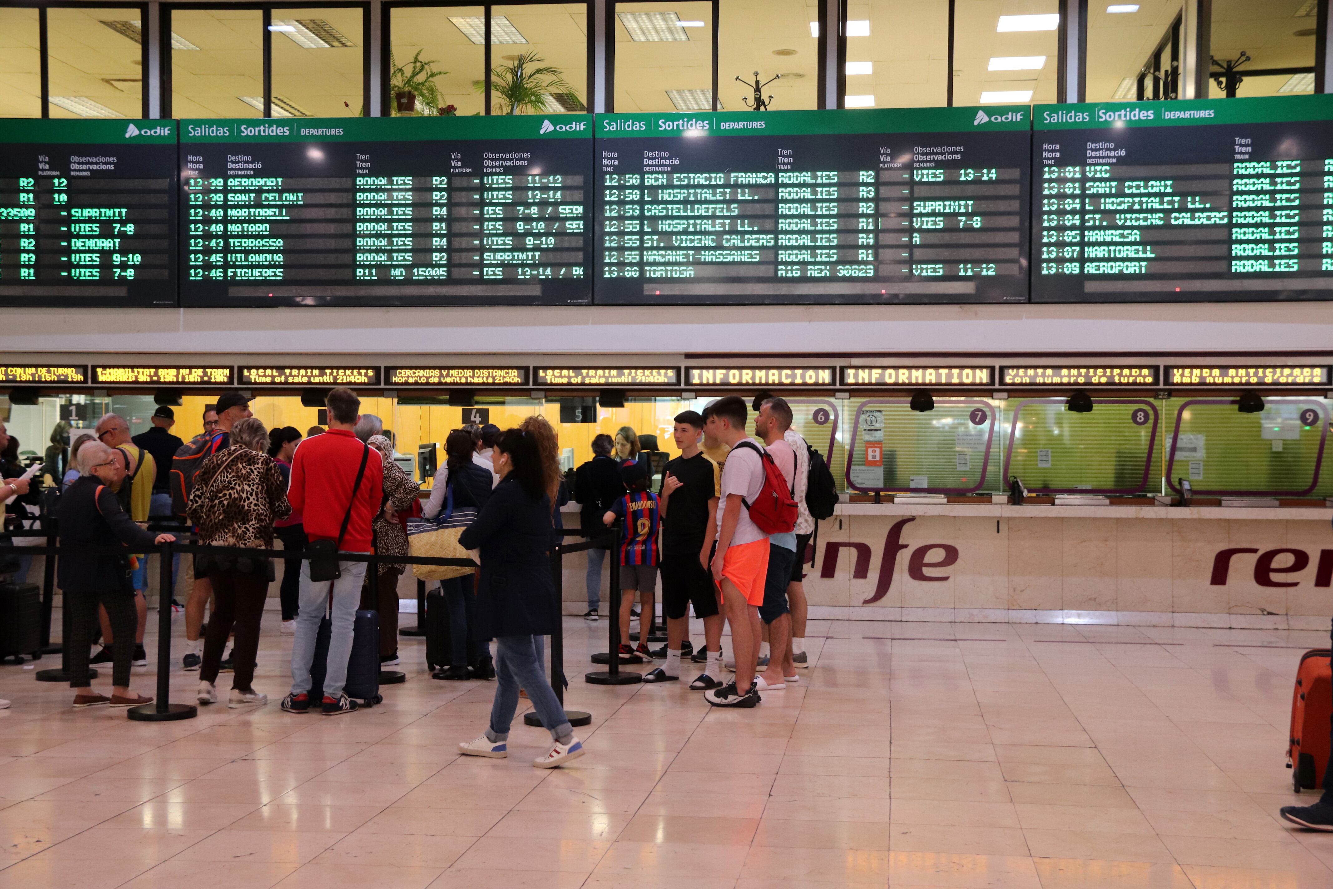 Cues de viatgers davant dels punts d&#039;informació de Sants-Estació, alguns d&#039;ells tancats