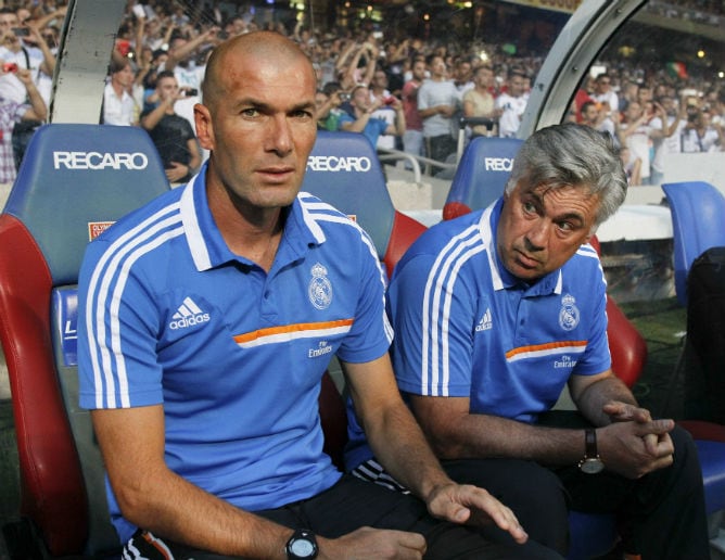 Zinedine Zidane y Carlo Ancelotti en el banquillo de Gerland