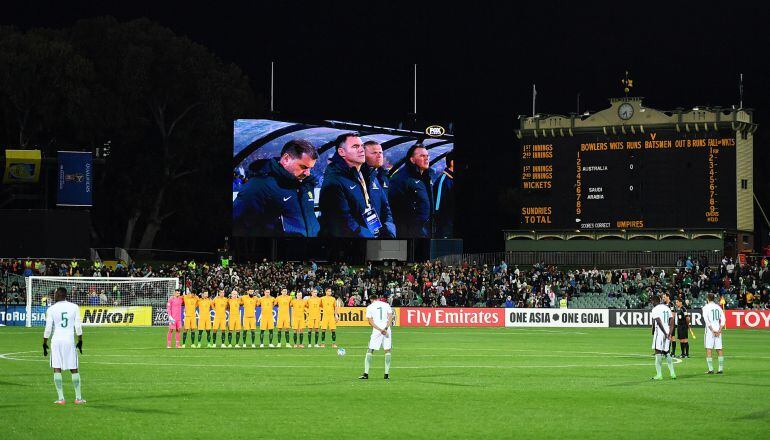 Los jugadores de Australia y de Arabia Saudí, durante el minuto de silencio