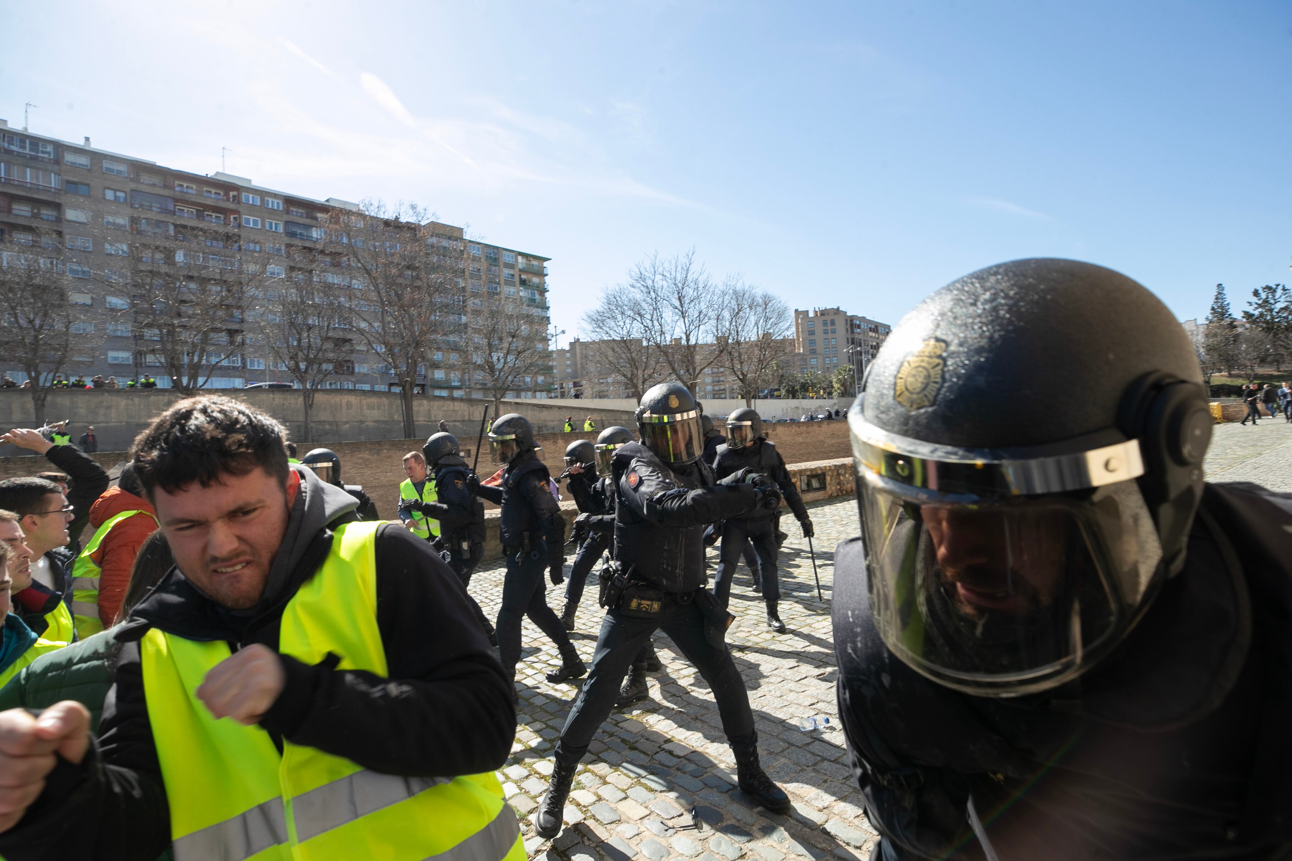 ZARAGOZA, 01/03/2024.- Un grupo de agricultores intenta romper el cordón policial en los alrededores del Palacio de La Aljafería, sede de las Cortes de Aragón, este viernes en Zaragoza. EFE/ Javier Belver
