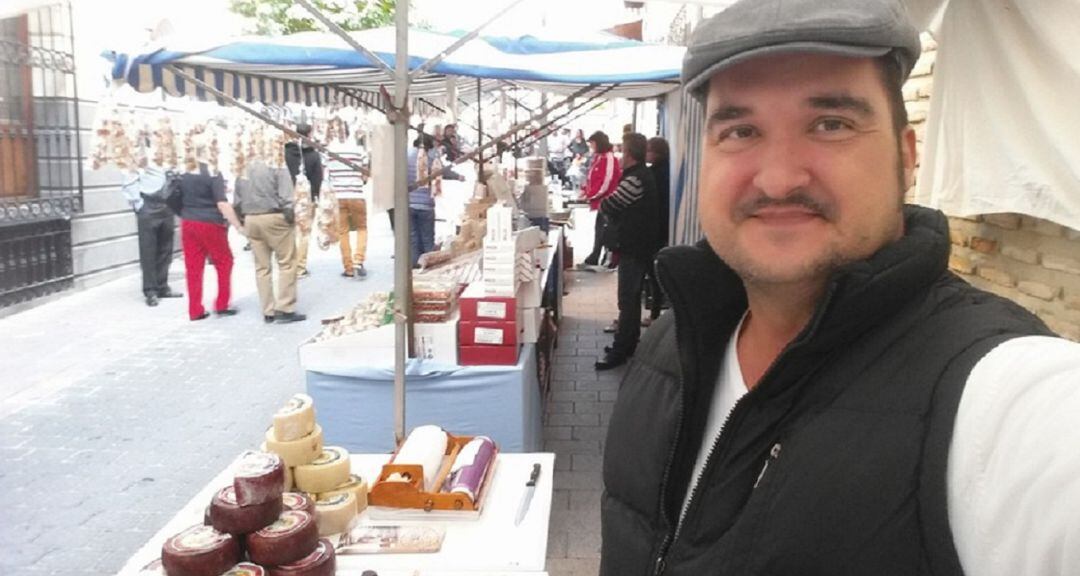 Félix Cano junto a su puesto de quesos artesanos en uno de los muchos mercadillos tradicionales que visita 