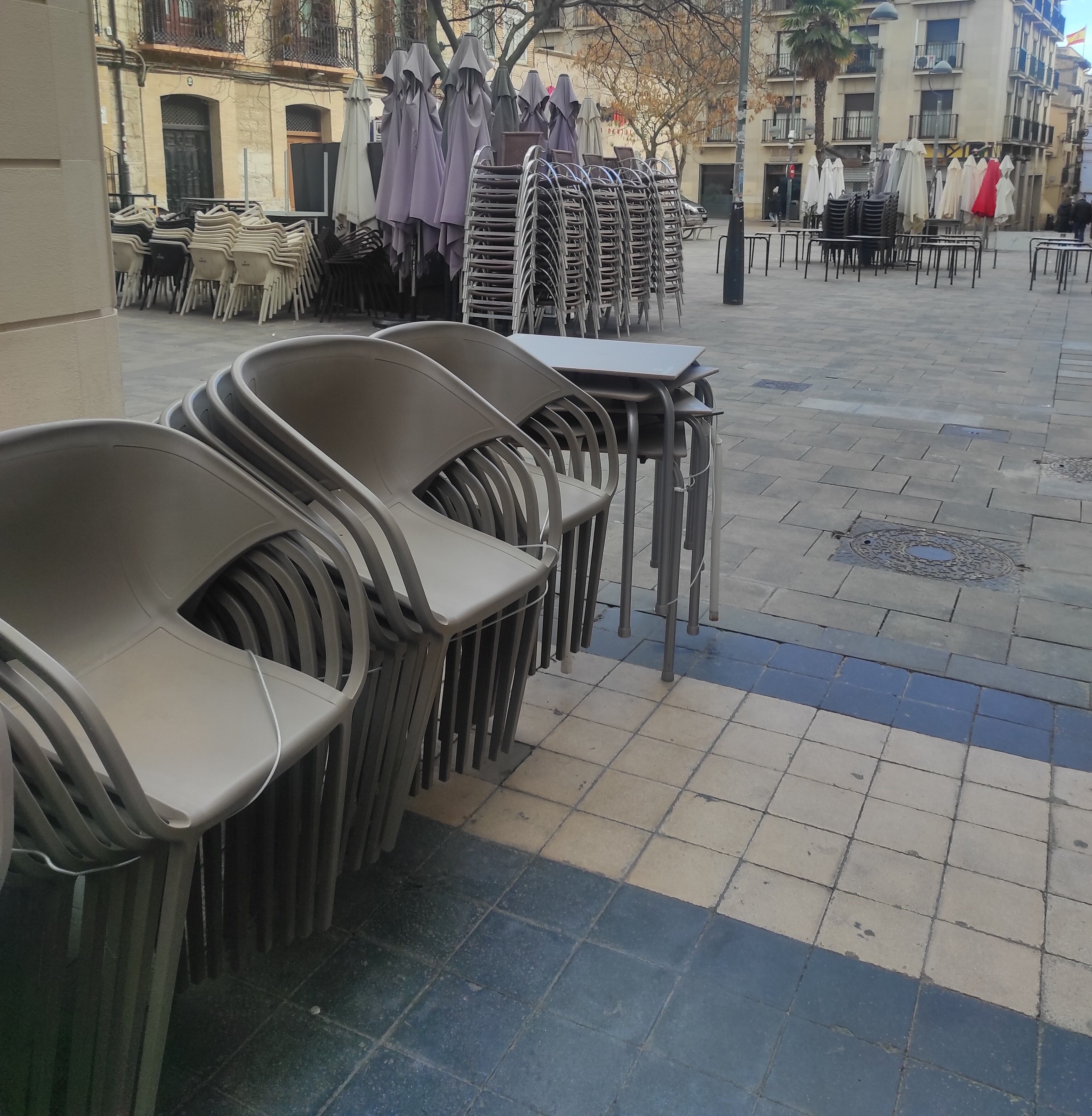 Sillas, mesas y sombrillas amontonadas en la calle Padre Huesca