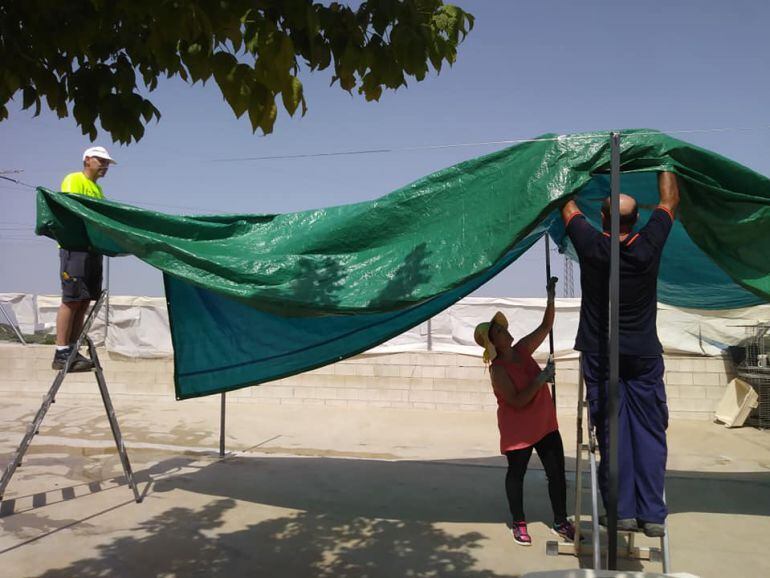 Voluntarios colocando toldos en el albergue.