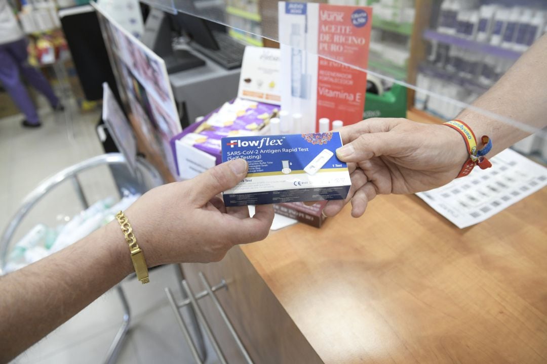 Un farmacéutico enseña un test de antígenos de detección del COVID-19 en un farmacia.