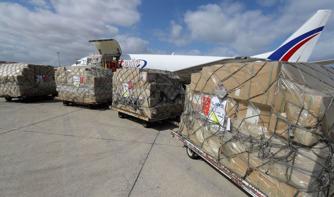  Operarios del aeropuerto de Gran Canaria descargan el avión carguero 737 que este martes ha llegado a la isla con 63.250 test, 2 millones de mascarillas y 18.250 batas desechables a bordo, material adquirido por el Gobierno de Canarias en China.