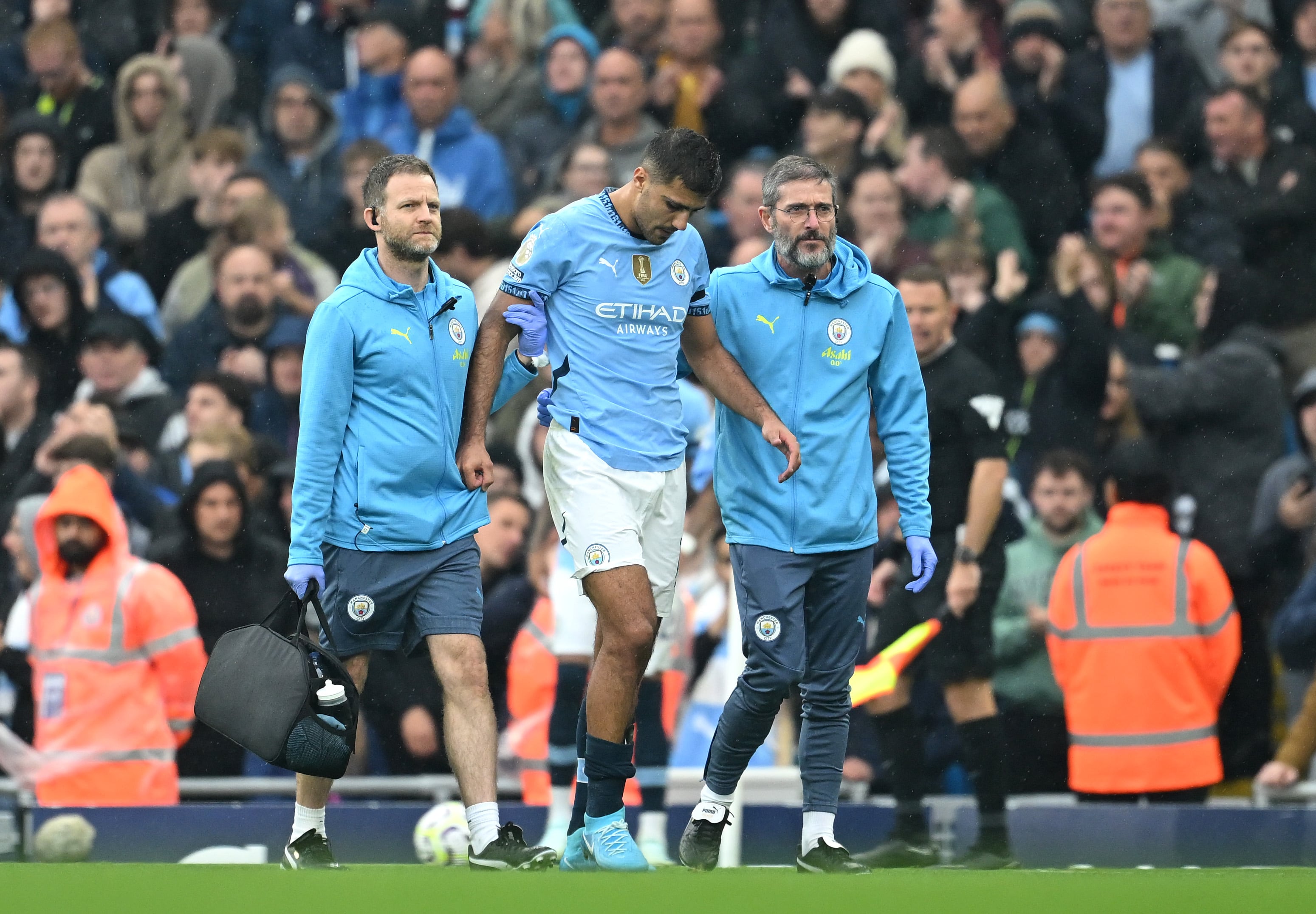 Rodri ayudado por los médicos del Manchester City a salir del campo