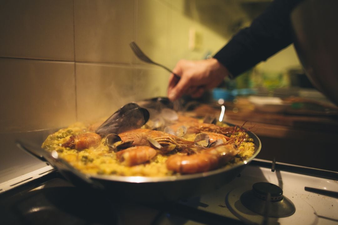 Un hombre cocina una paella