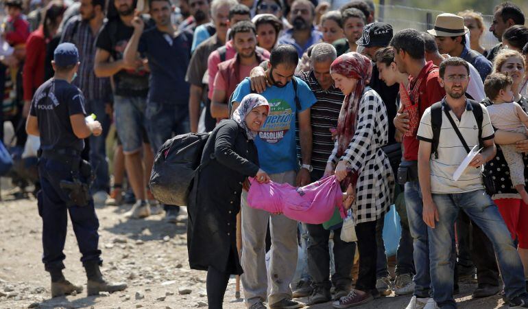 Refugiados esperan para poder cruzar la frontera entre Macedonia y Grecia cerca de Gevgelija (Macedonia).