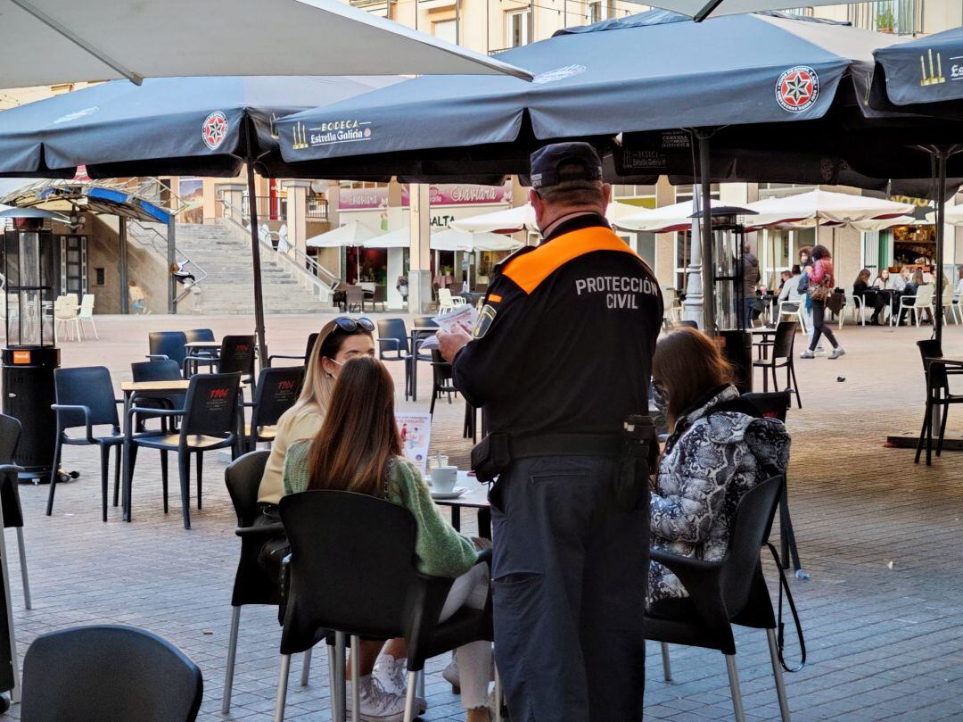Protección Civil repartiendo folletos a clientes de la hostelería en Elda