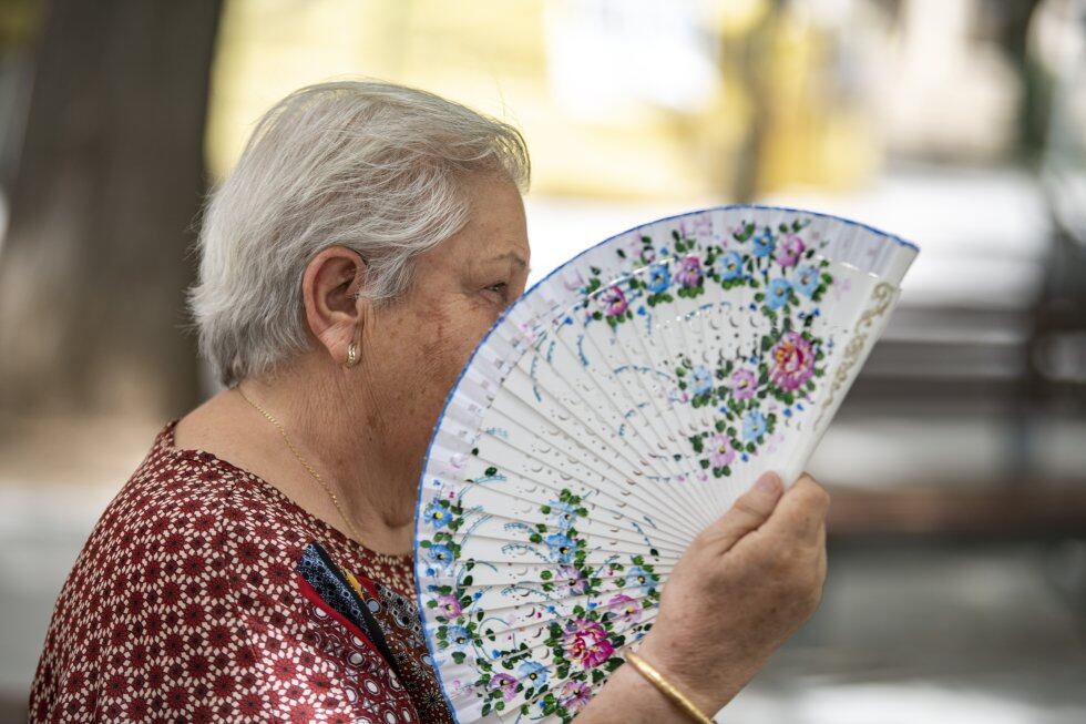 Una mujer combate el calor con un abanico.