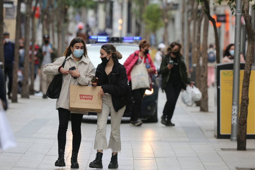 Varias personas caminan por la calle Fuencarral durante el primer día laboral tras el estado de alarma.