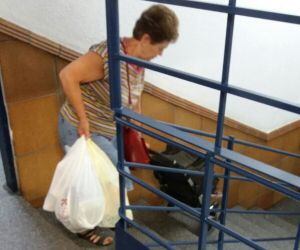 Una mujer baja con las escaleras del mercado de San Francisco con su carro de la compra