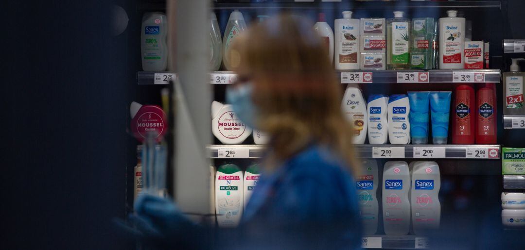 Una mujer protegida con mascarilla y guantes trabaja en una tienda durante el noveno día laborable desde que se decretó el estado de alarma en el país a consecuencia del coronavirus, en Barcelona.