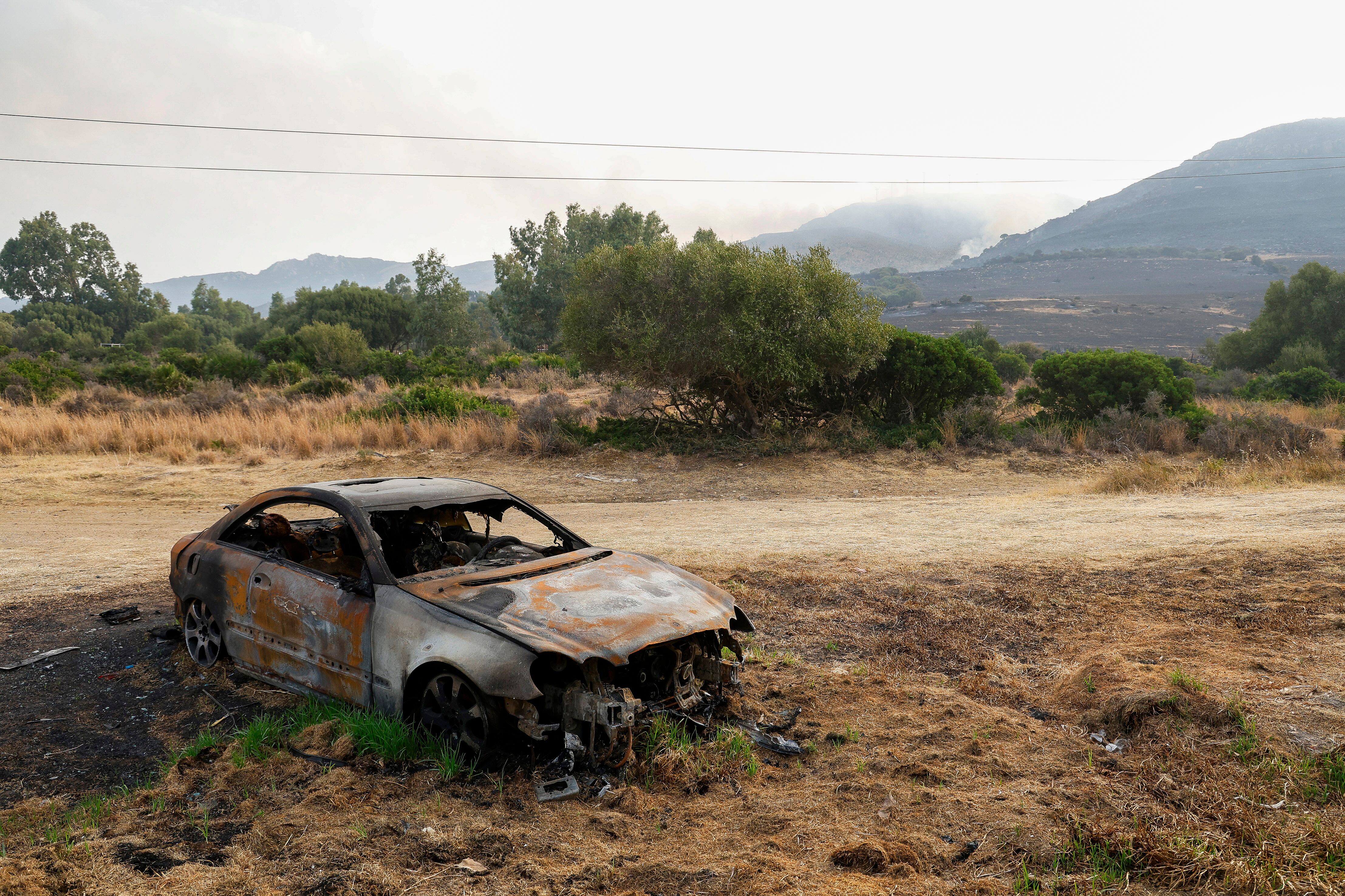 Un coche calcinado por el fuego en Tarifa. EFE/A.Carrasco Ragel.