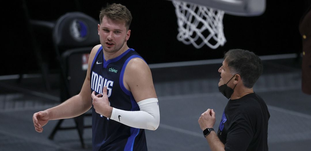 Luka Doncic charla con Mark Cuban durante un partido de la pasada temporada