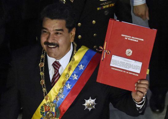 Venezuelan President Nicolas Maduro holds the folder with the powers request before submitting it to the president of the National Assembly, Diosdado Cabello (out of frame), during a session of the National Assembly in Caracas, on March 10, 2015. Maduro r